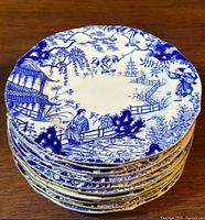 Stack of eleven plates showing pattern and gilt edges