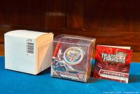 Photo showing the coin in original box, certificate of authenticity, and plain outer shipping box.