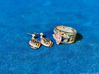 Ring and earrings on blue fabric background showing overall design and stones