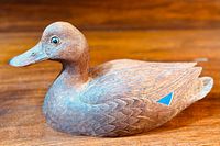 Side profile of the wooden Mallard Hen duck decoy displaying detailed feather carving, naturalistic paint tones, and blue wing patch.