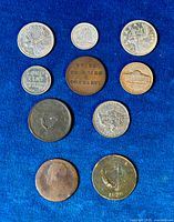 Overview photo of all ten coins laid out on a blue background showing mixed Canadian and US coins and tokens.