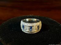 Front and slightly angled view of the chunky sterling silver ring with tanzanite and CZ stones.