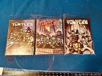 Full set of the three Teenage Mutant Ninja Turtles graphic novels arranged side by side, showing front covers.