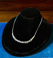 Close-up of the front braided strands displayed on a black velvet bust