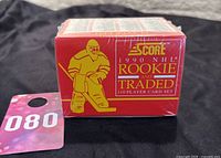 Front view of the factory sealed 1990 SCORE NHL Rookie and Traded 110 player card set box showing red packaging with yellow goalie illustration and text.