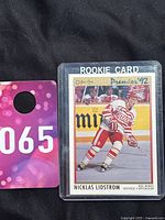 Front view of Nicklas Lidstrom rookie card encased in plastic holder, showing full card details and player in action.