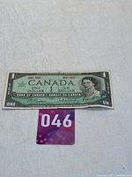 Front side of the 1967 Canada Centennial one dollar bill with Queen Elizabeth II portrait and Centennial text.