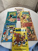 Overview of all 6 Walt Disney vintage comic books on a table, showing cover art for titles including Mickey Mouse, Donald Duck, Uncle Scrooge, and Walt Disney's Comics.