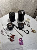 Overhead view showing all items laid out on table: necklaces, rings, brooches, earrings, pendants, pins, keychain, pen and loose rhinestones