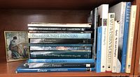 Shelf with 14 hardcover art books including titles like Impressionist Painters, Pissarro, Renoir's Portraits, Monet 'Nature Into Art', Canadian Impressions, Art of the Western World, among others.