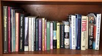 Photo showing a bookshelf with 20 assorted books including The Complete Astrologer, Prince Harry Spare, Swarovski Crystal, and others.