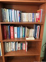 Photo of two wooden shelves filled with various books showing covers and spines with readable titles such as Canadian history, arthritis cure, and others.