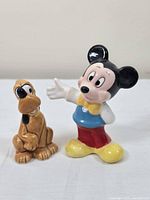 Photo showing Mickey Mouse and Pluto salt and pepper shakers side by side