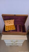 Open jewelry box showing velvet-lined interior and removable tray with multiple compartments
