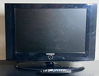 Front view of the 22-inch Samsung TV with visible wear and smudges on the screen and bezel. The TV is placed on its black oval base stand. The Samsung logo is visible below the screen.