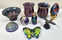 Overview of all glass items in lot including perfume bottle, tea light holders, bowl, paperweights, eggs, and butterfly piece