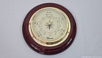 Front view of Thermor barometer showing round dial with weather indications and cherry wood frame.