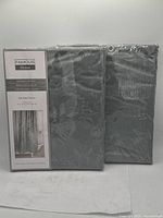 Photo of the packaged 2-pack Famous Home shower curtains with front label showing.