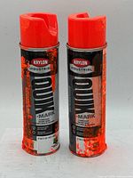 Photo of two Krylon Industrial fluorescent mark spray paint cans with red caps and black labels with orange accents.