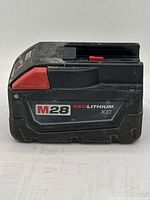 View of Milwaukee M28 Red Lithium XC battery showing label and wear marks.