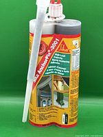 Front view of Sika AnchorFix 3001 epoxy anchoring adhesive dual cartridge with applicator nozzle, showing product label and usage illustrations.