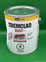 Front view of Tremclad Rust Paint can with yellow and white label, showing branding and product details.