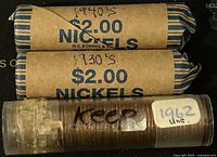 Photo showing two wrapped $2.00 rolls of Canadian nickels dated 1930s and 1940s and one plastic tube roll of 1962 uncirculated Canadian pennies.
