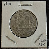 Obverse side of the 1940 Canadian 50 cent coin showing the Canadian coat of arms with '50 CENTS' and 'CANADA 1940' inscriptions. Coin housed in protective cardboard holder.