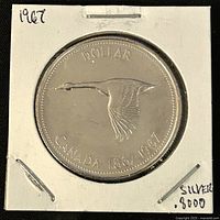 Obverse side of the coin showing a flying Canada goose with text 'DOLLAR', 'CANADA 1867-1967'