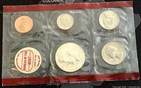Five US coins from 1969 in original sealed blister packaging. Coins arranged in two rows with the half dollar in center bottom and penny top left.