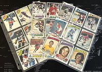 27 NHL collectible trading cards spread out loosely on a transparent sleeve sheet showing various players and teams like Maple Leafs, Rangers, Canadiens, Bruins, Capitals, and Redskins in color with vintage design.