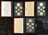 Overview of three Canadian proof coin sets in black folders opened to show the coins and description inserts.