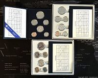 Overview of all three Canadian specimen coin sets from 1984, 1985, and 1986 in black and white trays with identification cards.