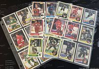 Front view of 27 assorted NHL O-Pee-Chee hockey cards spread out showing players in different team uniforms