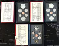 Overview of the three Canadian proof coin sets with coins arranged in protective black trays showing various coin denominations including double dollar coins.