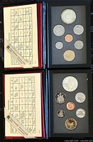 Two closed folders showing each with an information insert and coin window with 7 coins laid out including large double dollar coin.