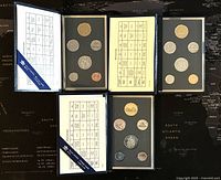 Overview of three Canadian specimen sets opened side by side with coin identification chart overlays