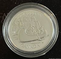 Obverse coin face showing the Voyageurs in a canoe with 1999 year and CANADA text.