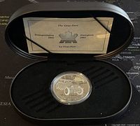 Photo showing the silver proof coin in original black display box with certificate inside lid.