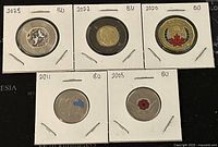 Five Canadian coloured coins from 2008, 2020, 2022, 2023, and 2001, each secured in a cardboard coin holder for protection and display.