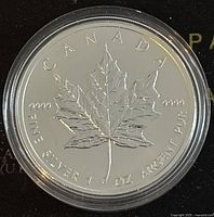 Obverse side of the coin showing the maple leaf design, purity, and silver content inscriptions.
