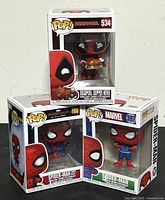 Photo of all three boxed Funko Pop! vinyl figures: Deadpool Supper Hero holding a turkey, Spider-Man Far From Home, and Spider-Man in Christmas sweater.