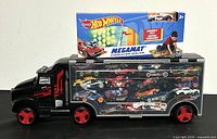 Black semi truck carrying case with clear side showing 20 die cast Hot Wheels cars stored inside, red wheels visible.