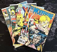 Four Marvel comic books stacked showing partial cover images including Wolverine, Uncanny X-Men, Ghost Rider, and Marvel Comics with The Punisher