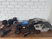 Full lot including RC truck chassis, three bodies, multiple replacement tires, charger, and battery