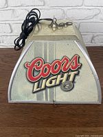 Front side view showing Coors Light logo and bubble panel with metal top and hanging chain