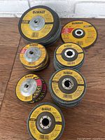 Full overview of all DeWalt grinding wheels in lot showing multiple stacks of grinding and flap discs with yellow labels