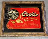 Front view of the vintage framed Coors Light beer mirror with red and black background and gold text and logo.
