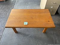 Top view of solid wood rectangular coffee table featuring a natural finish and slight surface wear.