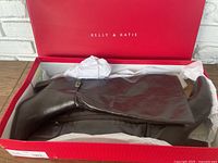 Kelly and Katie boots inside the original red Kelly & Katie branded box with tissue paper cushioning the boots.